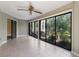This tiled lanai offers a ceiling fan and floor to ceiling windows looking out to lush landscaping at 3601 Quail Hollow Ln, Bradenton, FL 34210