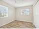 Well-lit bedroom featuring wood-look floors and two windows at 3777 Lake Bayshore Dr # H401, Bradenton, FL 34205