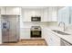 Updated kitchen with white shaker cabinets, quartz countertops, and stainless steel appliances at 3777 Lake Bayshore Dr # H401, Bradenton, FL 34205
