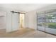Bedroom with barn door revealing bathroom and sliding glass doors to backyard at 4724 Seville Dr, Sarasota, FL 34235