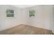 Spacious bedroom with light wood flooring and two windows at 4724 Seville Dr, Sarasota, FL 34235