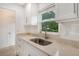 Clean kitchen boasts white cabinets, a stainless steel sink, and quartz countertops at 4724 Seville Dr, Sarasota, FL 34235