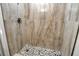 Spa-like shower with large, patterned wall tiles and pebble flooring at 4724 Seville Dr, Sarasota, FL 34235