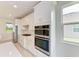 Modern kitchen with white cabinets, stainless steel appliances, and a tile backsplash at 4254 Golden Creek Ter, Parrish, FL 34219