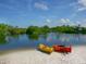 Two kayaks on a sandy beach by calm water at 12313 Baypointe Ter, Cortez, FL 34215
