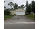 Traditional one-story home with an attached two car garage and a concrete driveway and a lawn at 27373 Sandrala Dr, Punta Gorda, FL 33955