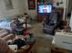 Cozy living room featuring multiple seating options, a large television, and personal decor throughout at 27373 Sandrala Dr, Punta Gorda, FL 33955