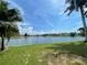 Scenic backyard view of a peaceful lake with lush green grass at 1822 Raven Glen Dr, Ruskin, FL 33570