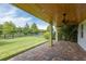 Covered patio with brick pavers overlooks a fenced backyard and pond at 2824 Esmeralda Dr, Sarasota, FL 34243