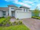 Two-story home with gray siding, brick pavers, and a two-car garage at 5827 Mezzana Run, Palmetto, FL 34221