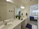 Bathroom with double vanity and view into bedroom at 5827 Mezzana Run, Palmetto, FL 34221