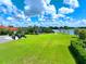 Green lawn area with playground near lake and community clubhouse at 5827 Mezzana Run, Palmetto, FL 34221