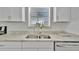 Clean kitchen featuring double sink and white cabinetry at 21403 Glendale Ave, Port Charlotte, FL 33952