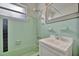 Retro bathroom with mint green tile and a classic white vanity at 21403 Glendale Ave, Port Charlotte, FL 33952