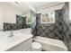 Clean bathroom with dark tile, white vanity, and bathtub at 2491 Hawthorne St, Sarasota, FL 34239