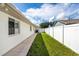 Side yard with concrete walkway and grassy area at 10268 Alexandria Ave, Englewood, FL 34224