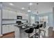 Modern kitchen with white cabinets, breakfast bar, and dark countertops at 164 Avens Dr, Nokomis, FL 34275