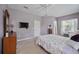 Well-lit bedroom with a flat-screen TV, built-in dresser and ensuite access at 164 Avens Dr, Nokomis, FL 34275