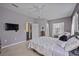 Spacious bedroom with a flat-screen TV, neutral decor, and ample natural light at 164 Avens Dr, Nokomis, FL 34275