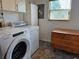 Bright laundry room, washer, dryer, and folding table at 2631 Fiesta Dr, Venice, FL 34293