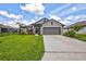 One-story home with gray exterior, landscaped lawn, and two-car garage at 16162 61St E Ln, Parrish, FL 34219