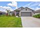 One-story home with gray exterior, landscaped lawn, and two-car garage at 16162 61St E Ln, Parrish, FL 34219