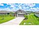 Single-Gathering home with gray exterior, two-car garage and solar panels at 16162 61St E Ln, Parrish, FL 34219