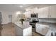 Modern kitchen with white cabinets, granite island, and stainless steel appliances at 16162 61St E Ln, Parrish, FL 34219