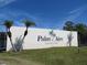 The Palm-Aire Country Club sign with palm trees against a sunny sky at 4939 Lakescene Pl, Sarasota, FL 34243