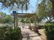 Pool entrance with pergola, disability parking sign, and lush landscaping at 4939 Lakescene Pl, Sarasota, FL 34243