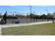 Outdoor tennis courts surrounded by green grass and a secure fence at 4939 Lakescene Pl, Sarasota, FL 34243