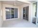 Covered outdoor patio with sliding glass doors and a ceiling fan overlooking a garden and a lake at 5107 Whispering Oaks Dr, North Port, FL 34287