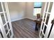 Home office with wood desk, French doors, and gray vinyl plank flooring at 5107 Whispering Oaks Dr, North Port, FL 34287