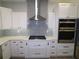Modern kitchen with white cabinets, stainless steel appliances, and a gas cooktop at 5107 Whispering Oaks Dr, North Port, FL 34287