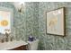 Stylish powder room with a unique green leaf wallpaper and gold accents at 3973 Boca Pointe Dr, Sarasota, FL 34238