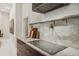 Contemporary kitchen with sleek countertops, a built-in cooktop, and stylish backsplash at 3973 Boca Pointe Dr, Sarasota, FL 34238