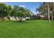 Expansive backyard with a large tree, lush lawn, and partial home view at 3973 Boca Pointe Dr, Sarasota, FL 34238