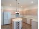Kitchen with island, light wood cabinets, and tile flooring at 4939 Lakescene Pl, Sarasota, FL 34243