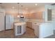 Kitchen features an island, light wood cabinets, and tile flooring at 4939 Lakescene Pl, Sarasota, FL 34243