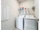 Bright laundry room with washer, dryer, and shelving at 8313 Ocean Tides Cv, Parrish, FL 34219