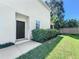 Side view of house with dark brown door and well-maintained landscaping at 6428 Boxgrove Dr, Sarasota, FL 34240