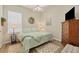 Bedroom with light green bedding, wooden dresser, and ceiling fan at 5111 51St W Ln, Bradenton, FL 34210