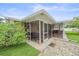 Screened porch with a flagstone patio and backyard access at 2611 Sunnyside St, Sarasota, FL 34239