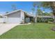 Charming mid-century modern home with white and gray exterior and teal door at 305 55Th Nw St, Bradenton, FL 34209