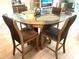 Round glass dining table with four brown chairs in a condo at 6611 Stone River Rd # 104, Bradenton, FL 34203