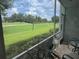 Screened lanai overlooking a lush green golf course at 6611 Stone River Rd # 104, Bradenton, FL 34203