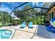 Relaxing poolside patio with lounge chairs under screened enclosure at 7606 91St E St, Palmetto, FL 34221