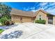 Three-car garage with tan doors and stone accents at 7606 91St E St, Palmetto, FL 34221