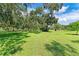 Large grassy backyard with mature oak trees and lush landscaping at 7606 91St E St, Palmetto, FL 34221