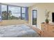 Bedroom with queen bed, lovely bedding, and balcony access at 5855 Midnight Pass Rd # 420, Sarasota, FL 34242